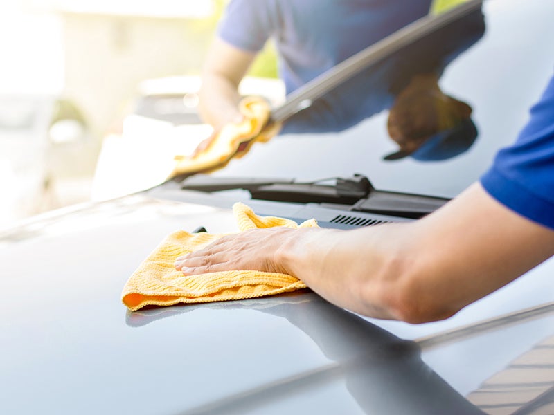 A technician wiping down a car