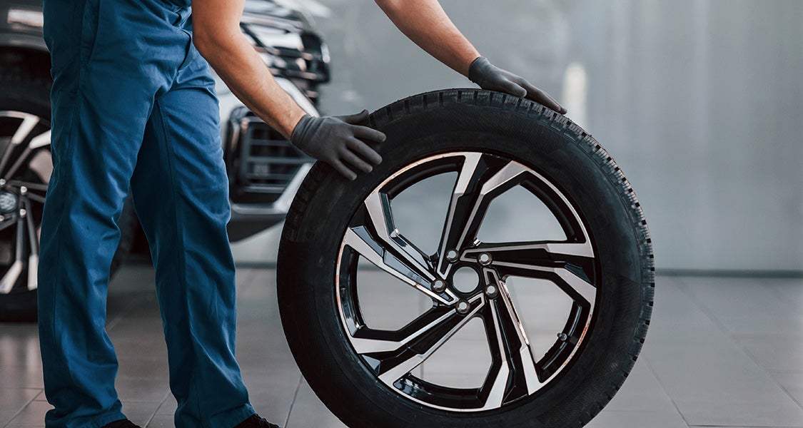 A technician holds a tire