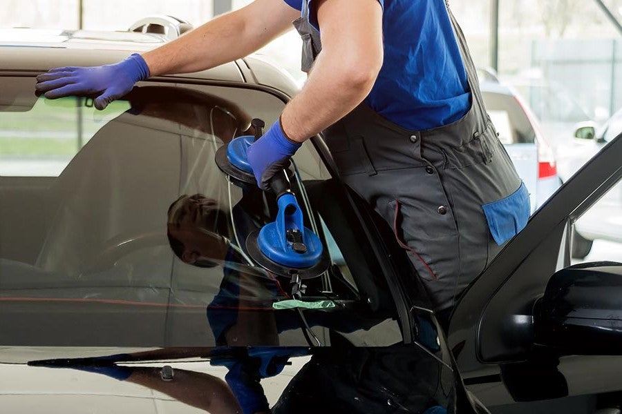 A technician replacing a windshield